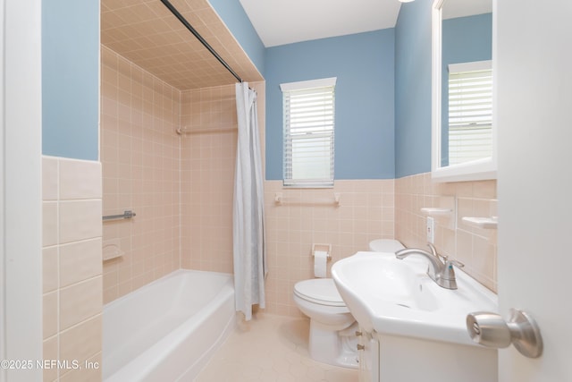 bathroom featuring tile patterned flooring, toilet, shower / tub combo, vanity, and tile walls