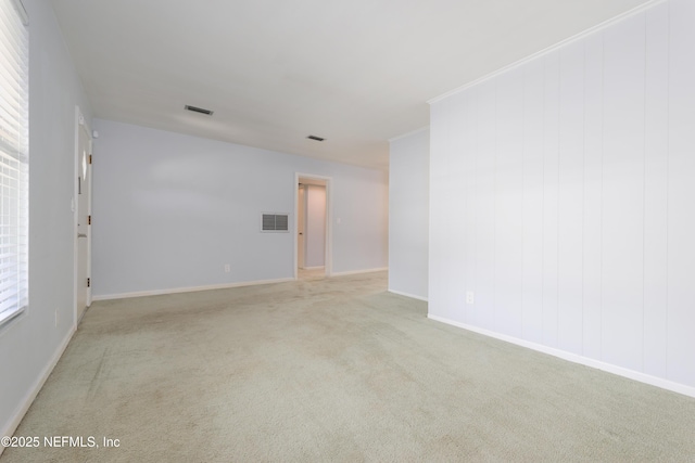 unfurnished room featuring baseboards, ornamental molding, visible vents, and light colored carpet