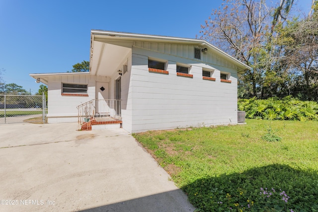 view of front of home featuring a front lawn, board and batten siding, and fence