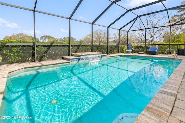 pool with glass enclosure, a jacuzzi, and a patio