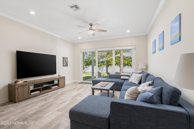 living area featuring light wood-style flooring, visible vents, baseboards, and ornamental molding