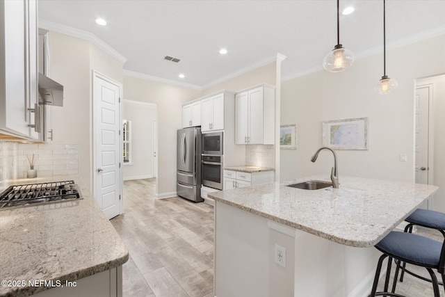 kitchen featuring light stone counters, visible vents, appliances with stainless steel finishes, a sink, and a kitchen breakfast bar