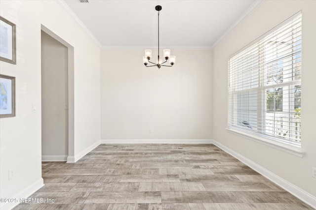 spare room with light wood-type flooring, baseboards, ornamental molding, and a chandelier