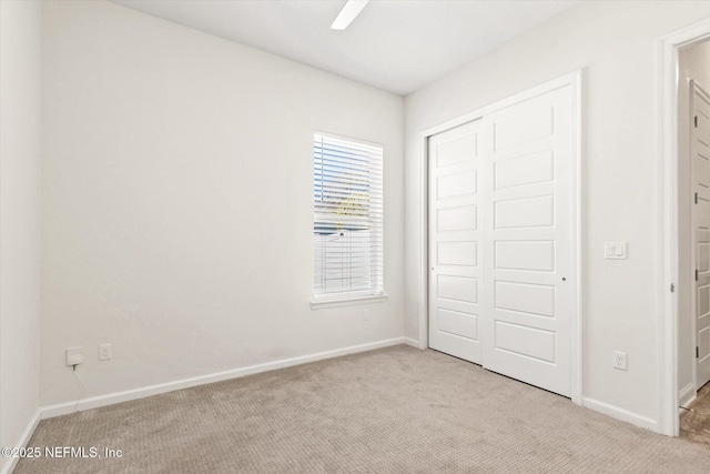 unfurnished bedroom featuring a closet, carpet flooring, ceiling fan, and baseboards