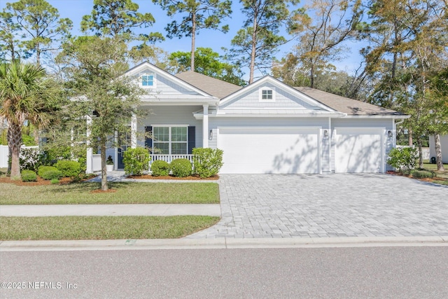 view of front of house featuring decorative driveway, an attached garage, and a front yard