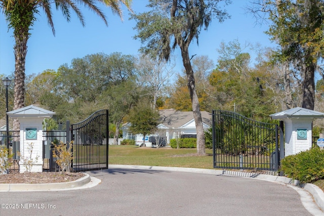 view of street with a gate, curbs, and a gated entry