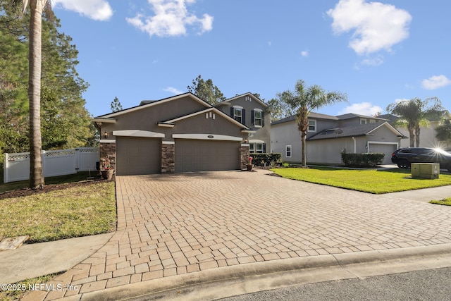 view of front facade with decorative driveway, stucco siding, an attached garage, stone siding, and a front lawn