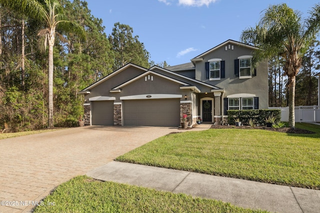 traditional-style home with an attached garage, fence, decorative driveway, and stucco siding