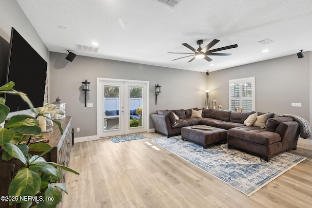 living area with visible vents, plenty of natural light, and light wood finished floors