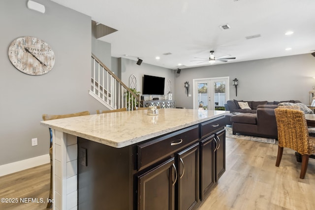 kitchen with open floor plan, french doors, and light wood-type flooring