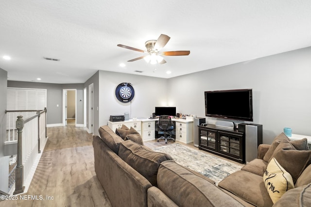 living room featuring light wood finished floors, baseboards, visible vents, a ceiling fan, and recessed lighting