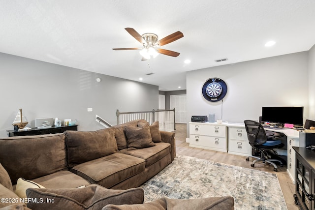 living room featuring light wood-style flooring, a ceiling fan, visible vents, and recessed lighting