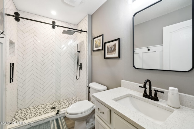 full bath featuring a stall shower, vanity, and toilet