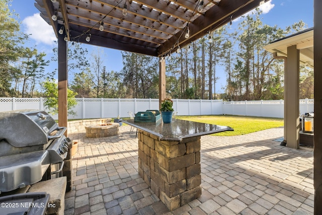 view of patio / terrace with a fenced backyard, a fire pit, and a pergola