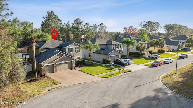 exterior space featuring decorative driveway, a front yard, and a residential view