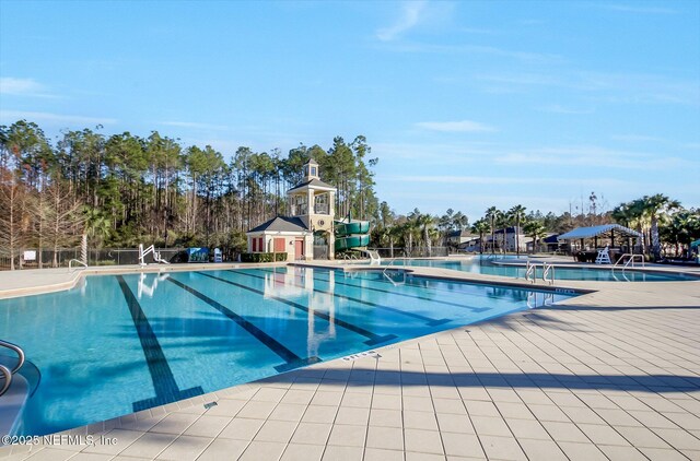 pool with a patio and fence