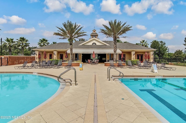 community pool with a patio and fence