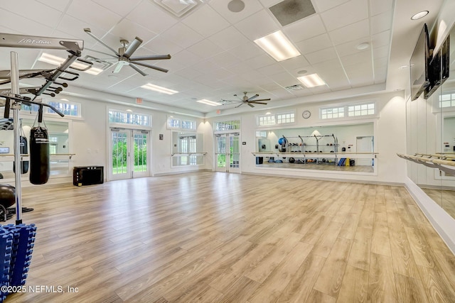 exercise area featuring baseboards, visible vents, a ceiling fan, and wood finished floors