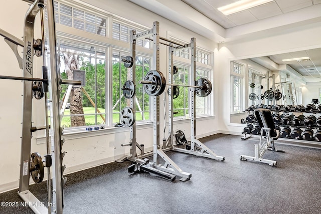 exercise room featuring a wealth of natural light and baseboards