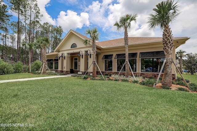 view of front of home with a front yard and stucco siding