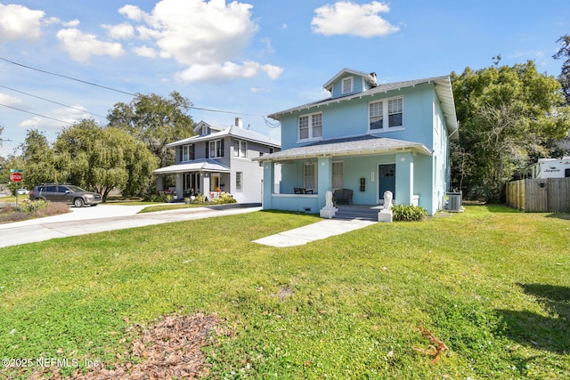 traditional style home featuring cooling unit, covered porch, fence, driveway, and a front yard