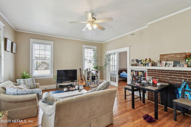 living room with baseboards, wood finished floors, a ceiling fan, and crown molding