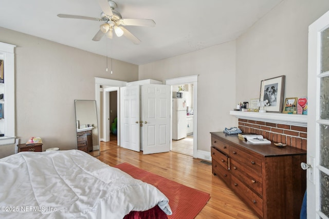 bedroom with ceiling fan, light wood-style flooring, freestanding refrigerator, and baseboards