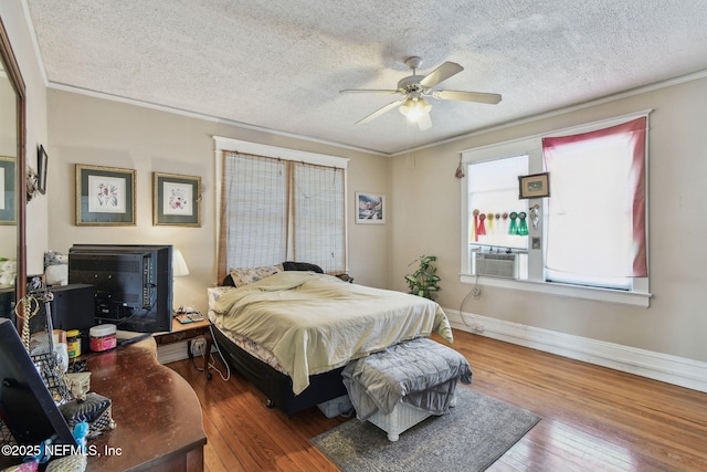 bedroom featuring ornamental molding, cooling unit, a textured ceiling, and hardwood / wood-style flooring