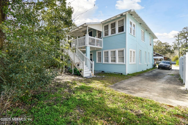 rear view of property with crawl space and stairway