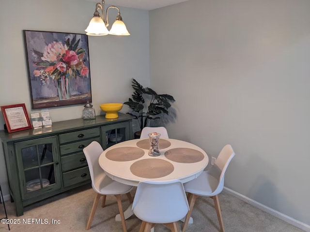 dining area featuring baseboards and light colored carpet