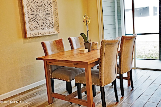 dining space with wood finish floors and baseboards