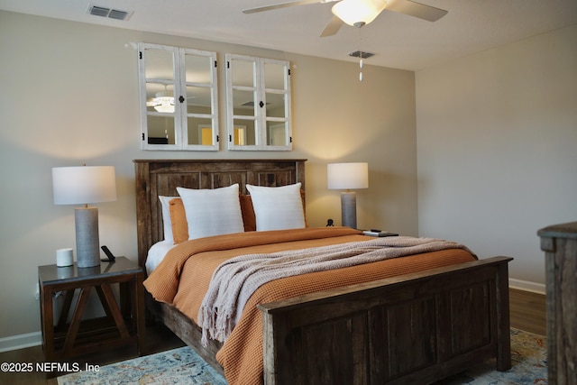 bedroom featuring ceiling fan, wood finished floors, visible vents, and baseboards