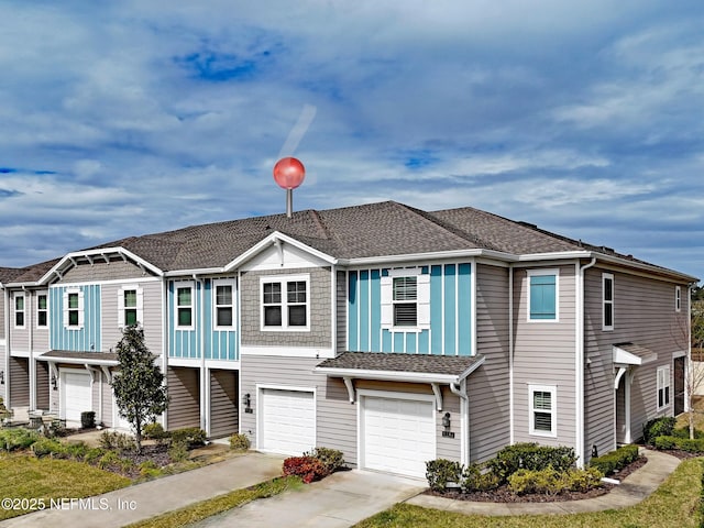 view of property featuring driveway, roof with shingles, and an attached garage