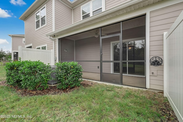 view of property exterior featuring a sunroom and a lawn