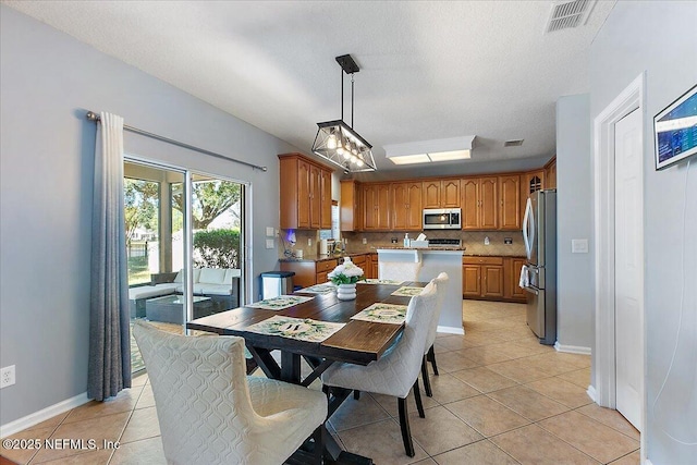 dining room with light tile patterned floors, visible vents, and baseboards