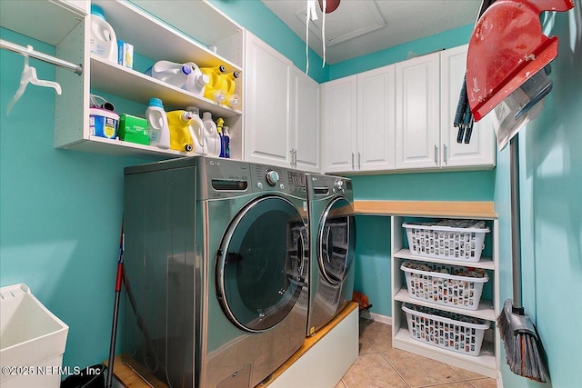 laundry area with light tile patterned floors, washing machine and dryer, cabinet space, and a sink