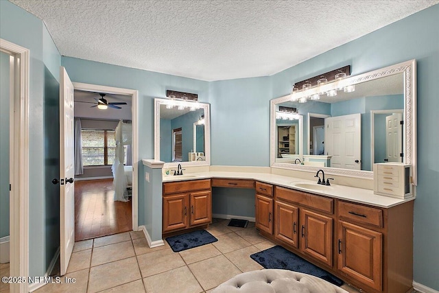 full bathroom with tile patterned flooring, double vanity, ceiling fan, and a sink