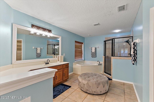 bathroom with a garden tub, vanity, a shower stall, and tile patterned flooring