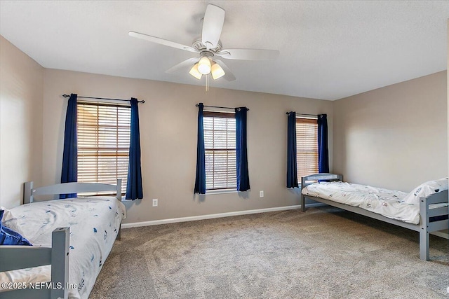 carpeted bedroom featuring baseboards and ceiling fan