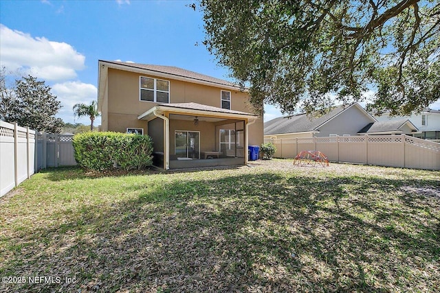 back of property with a yard, stucco siding, a fenced backyard, and a sunroom