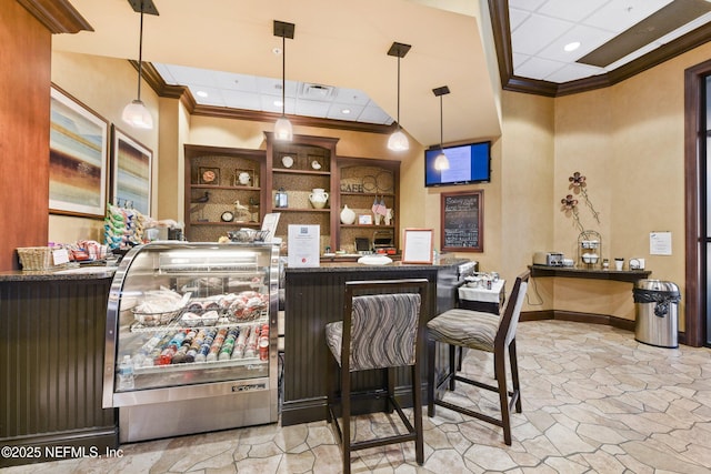 bar featuring crown molding, a high ceiling, baseboards, and stone finish flooring