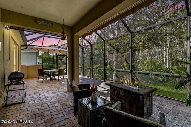 view of patio with outdoor dining area and a lanai