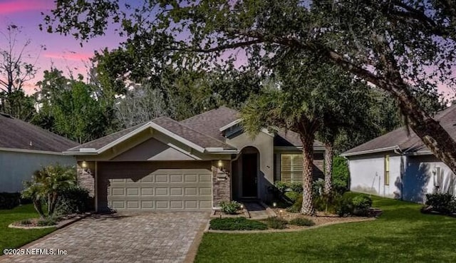 single story home featuring an attached garage, a lawn, and driveway