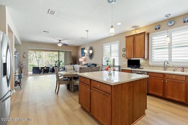 kitchen with light countertops, open floor plan, visible vents, and appliances with stainless steel finishes