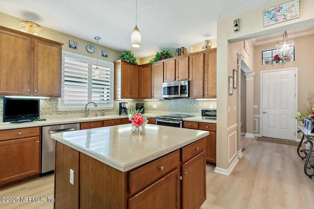 kitchen featuring brown cabinetry, decorative backsplash, stainless steel appliances, and light countertops