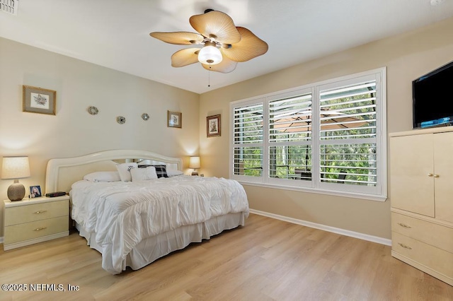 bedroom with light wood finished floors, visible vents, ceiling fan, and baseboards