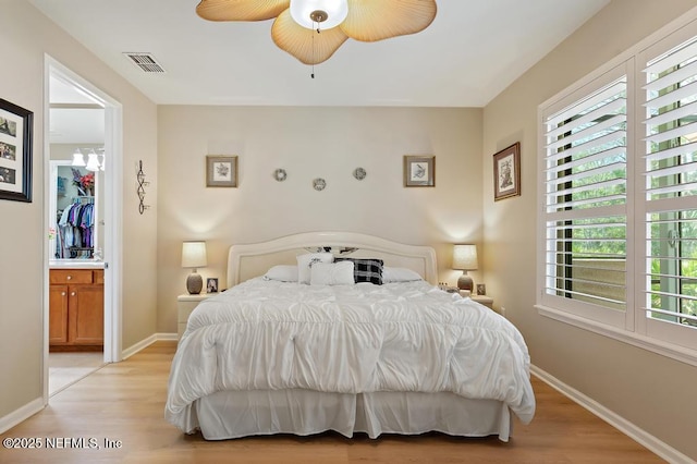 bedroom with light wood-style flooring, visible vents, baseboards, and ceiling fan