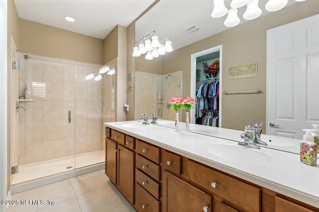 bathroom with tile patterned flooring, a stall shower, double vanity, and a sink