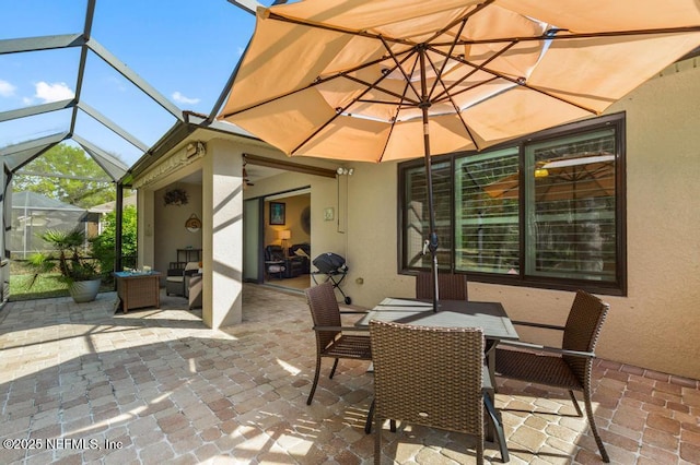 view of patio / terrace featuring glass enclosure and outdoor dining area