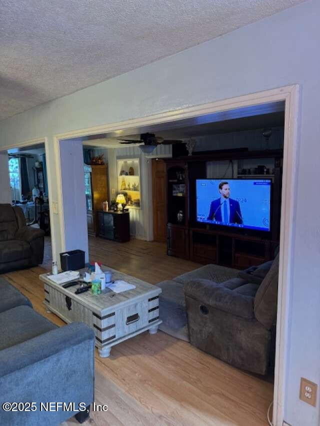 living area with a textured ceiling and wood finished floors